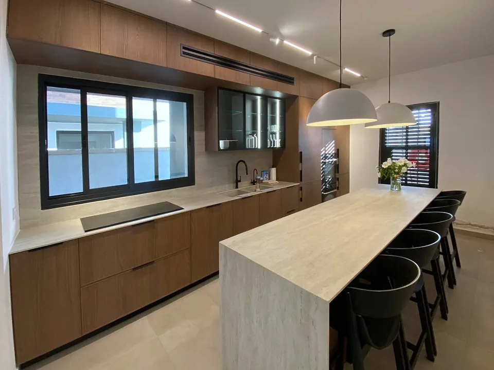 Residential kitchen with Delgado slim shaker fronts in a warm woodgrain finish and an island