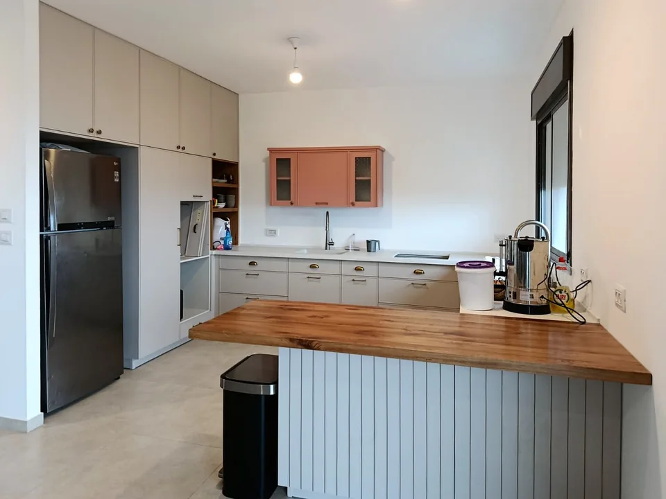 Residential kitchen with light grey Delgado slim shaker fronts and a terracotta vitrine wall cabinet